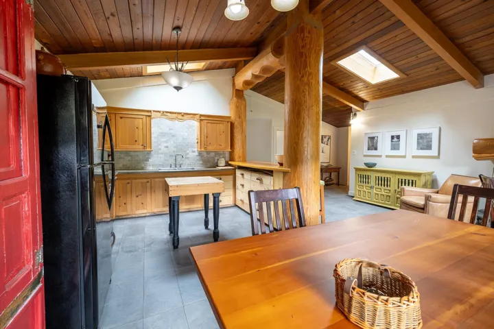Dining space with wood ceiling, vaulted ceiling with skylight, and tile patterned floors