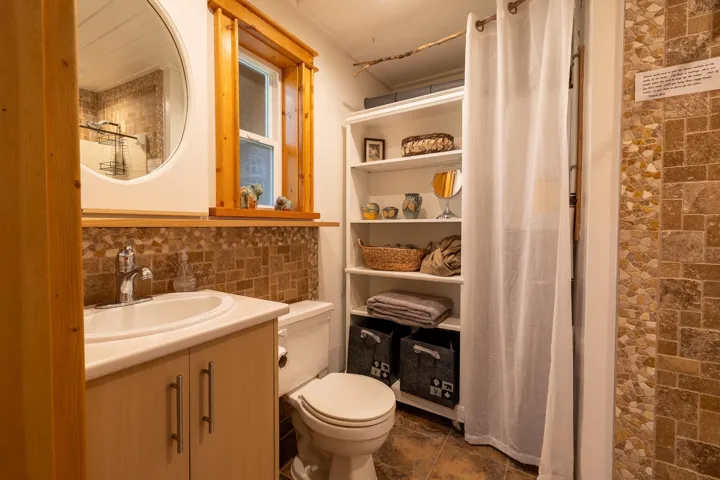 Bathroom with vanity, toilet, and tile walls