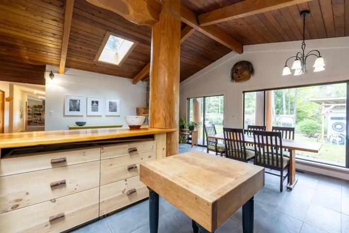 Interior space featuring lofted ceiling with skylight, an inviting chandelier, tile patterned flooring, and wood ceiling