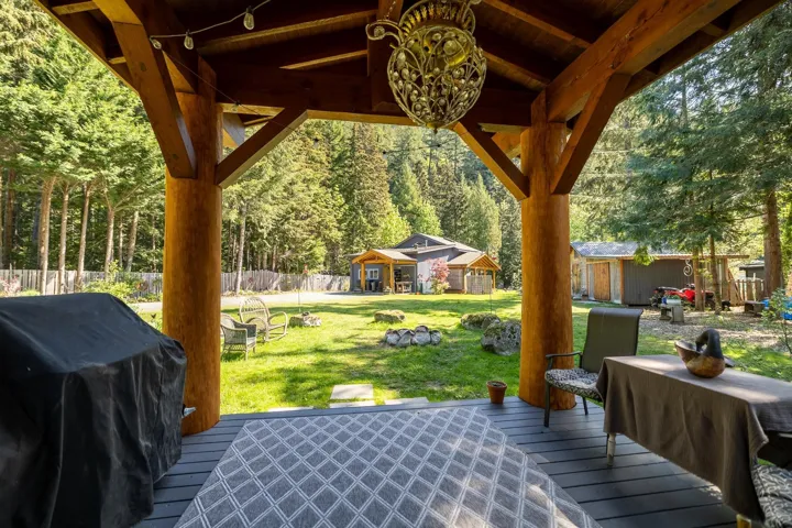 View of patio / terrace featuring a deck, an outbuilding, grilling area, and fence