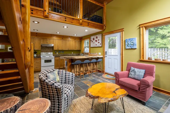 Living room with recessed lighting, baseboards, a high ceiling, and stone tile floors