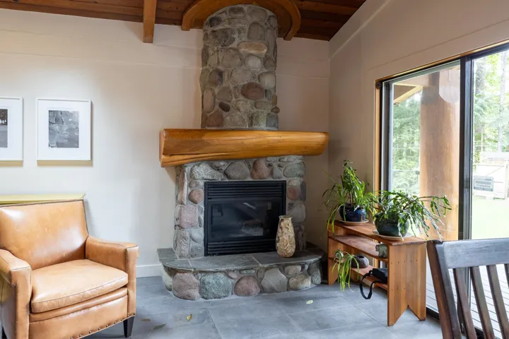 Living area featuring a fireplace, beam ceiling, and wood ceiling
