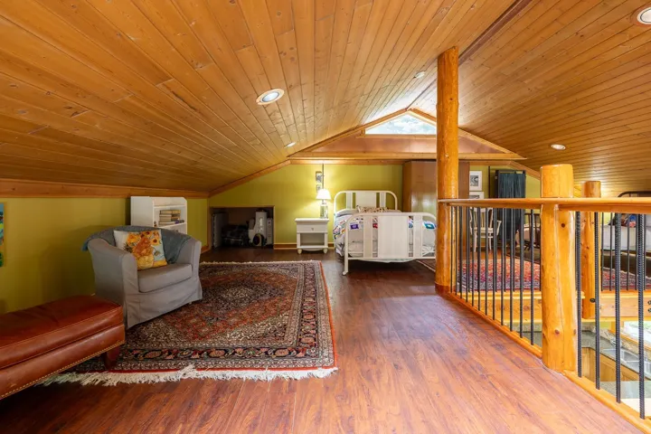 Bedroom featuring multiple windows, wooden ceiling, vaulted ceiling, and wood finished floors
