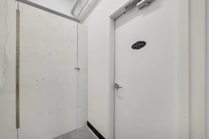 White paneled door with a brushed nickel handle and overhead door closer