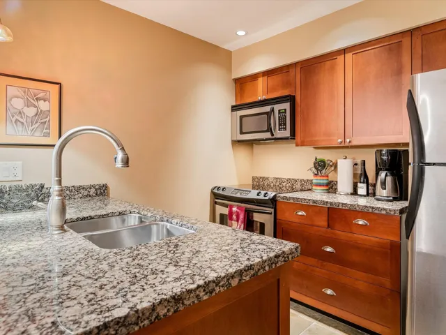 Kitchen with recessed lighting, a sink, brown cabinetry, and appliances with stainless steel finishes