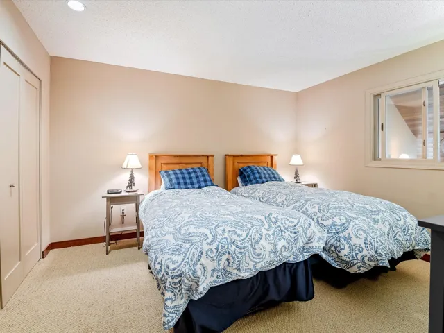 Bedroom featuring carpet floors, baseboards, and a textured ceiling