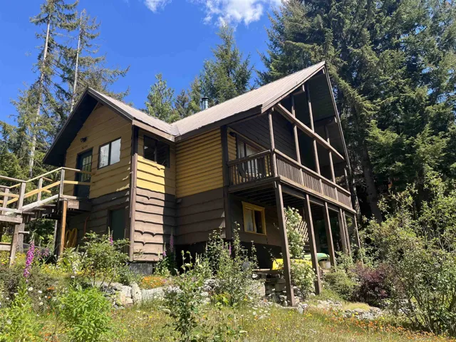 Two-story cabin-style residence featuring a yellow and brown horizontal siding exterior