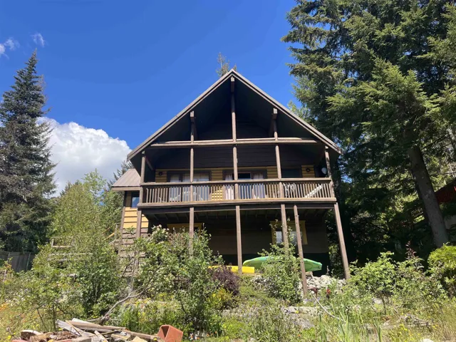 Two-story cabin-style residence featuring a prominent A-frame roofline and dual-level wooden balconies