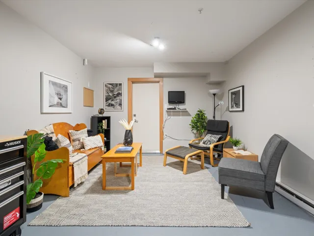 Living area with finished concrete flooring and a baseboard heating unit