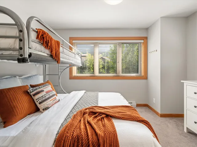 Bedroom with light carpet and a baseboard radiator