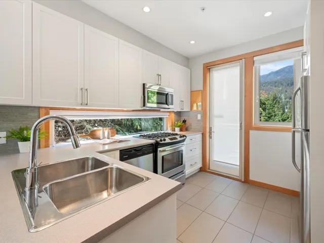 Kitchen featuring white cabinets, light countertops, stainless steel appliances, decorative backsplash, and recessed lighting