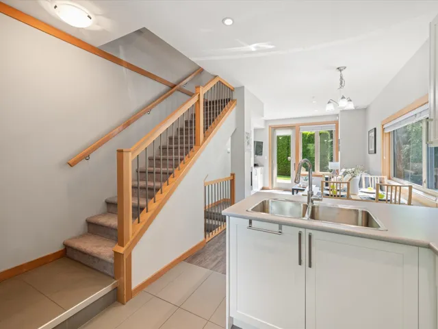 Kitchen featuring white cabinetry, hanging light fixtures, light tile patterned floors, light countertops, and a chandelier