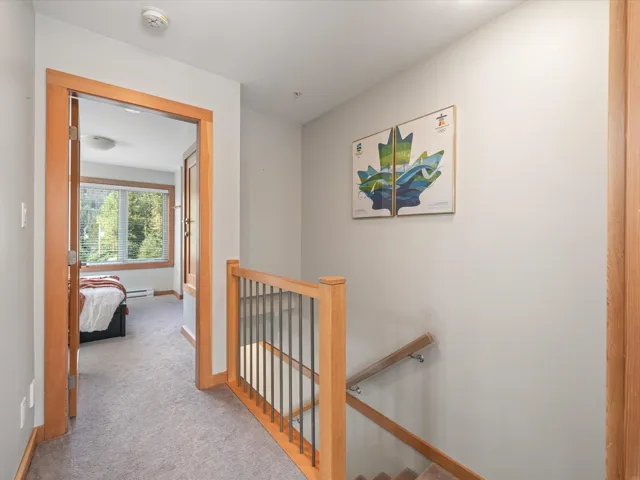 Hallway with an upstairs landing and carpet flooring