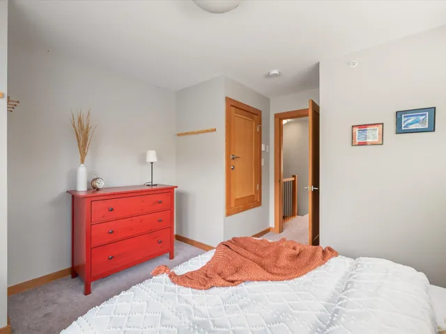 Bedroom featuring light carpet and baseboards