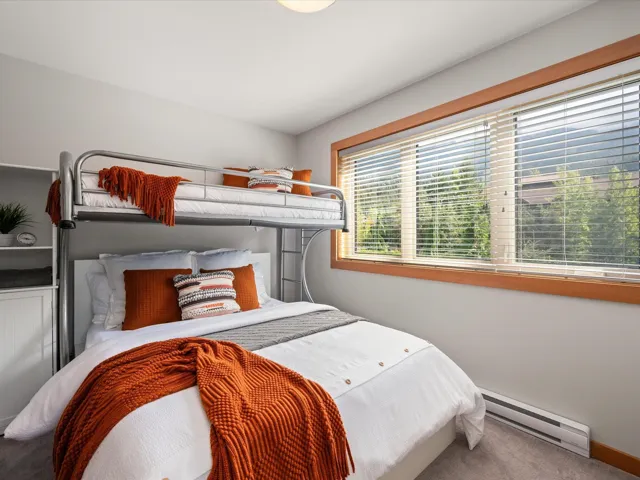 Carpeted bedroom featuring a baseboard heating unit