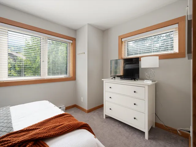 Bedroom featuring light colored carpet and a baseboard heating unit