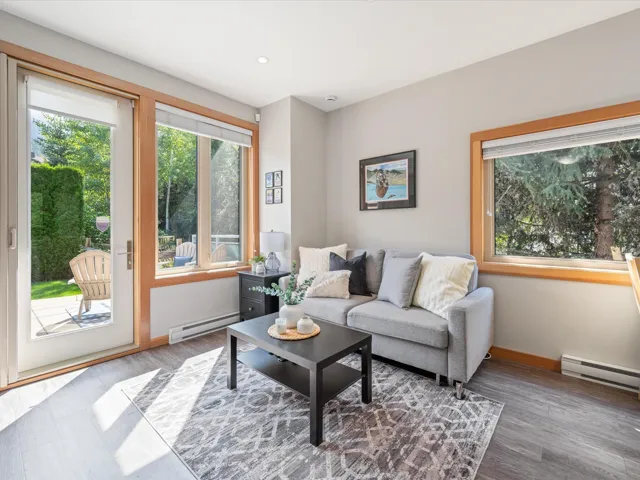 Living area with a baseboard heating unit, wood finished floors, and recessed lighting