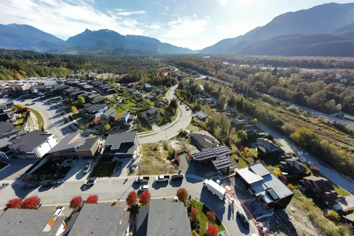 Aerial view of property and surrounding area with nearby suburban area and a mountainous background