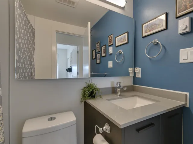 Full bath featuring visible vents, toilet, and vanity