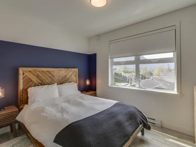 Bedroom with baseboard heating, baseboards, and wood finished floors