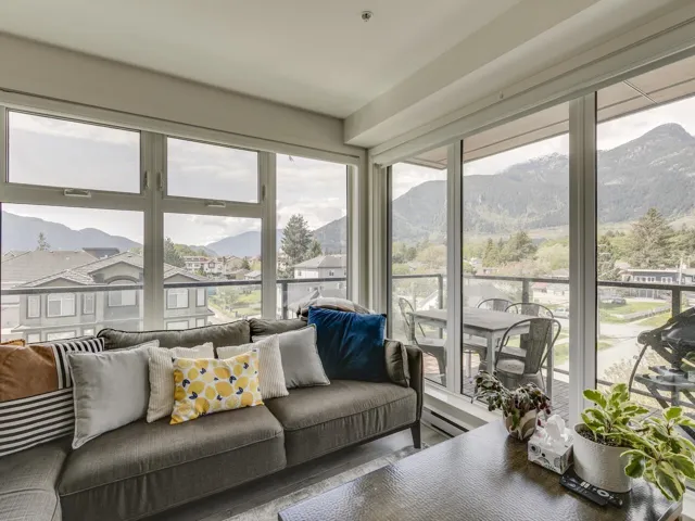 Sunroom with baseboard heating, a mountain view, and wood finished floors