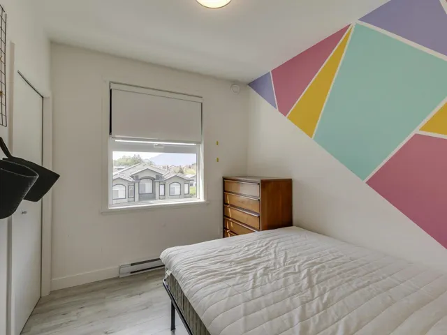 Bedroom featuring baseboards, a baseboard radiator, and wood finished floors
