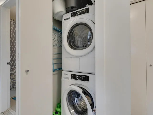 Washroom featuring laundry area and stacked washer / dryer