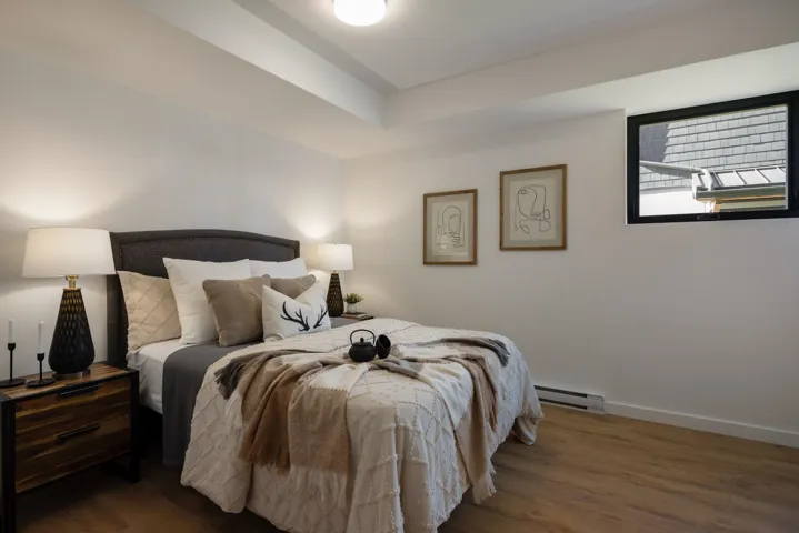 Bedroom with wood finished floors and a baseboard radiator