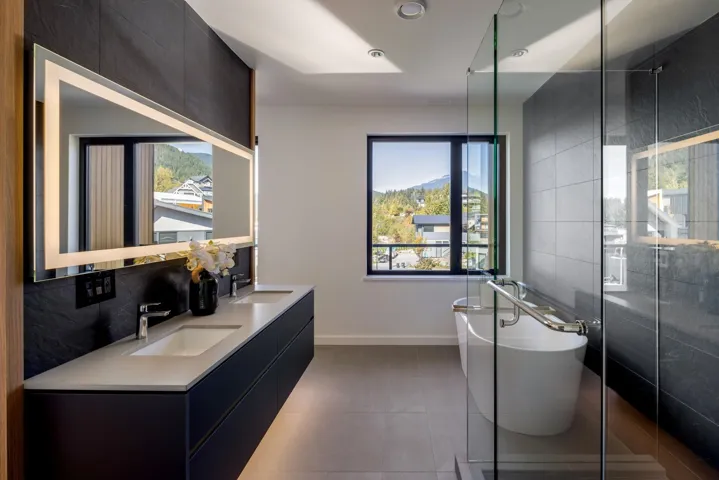 Bathroom with tile walls, double vanity, a soaking tub, plenty of natural light, and a stall shower