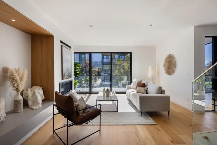 Living room with light wood finished floors, recessed lighting, a fireplace, and stairs