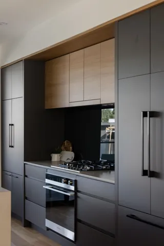 Kitchen featuring stainless steel appliances, gray cabinets, modern cabinets, and light wood-type flooring