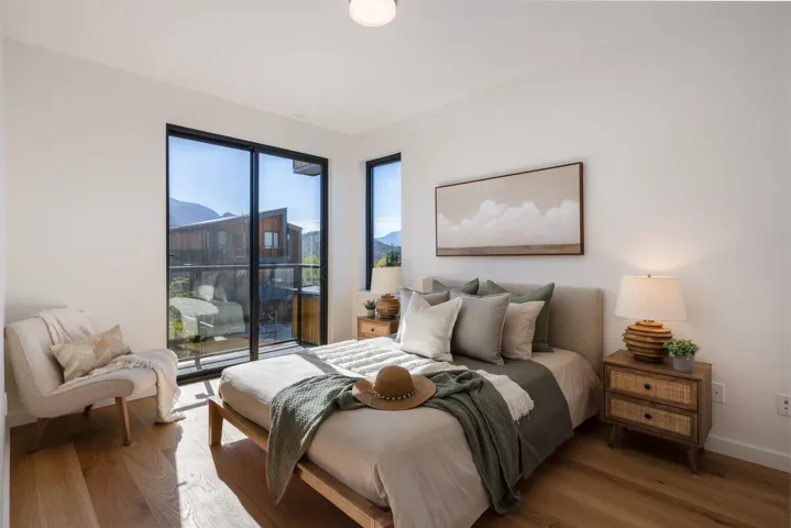 Bedroom with wood finished floors, access to outside, and a mountain view
