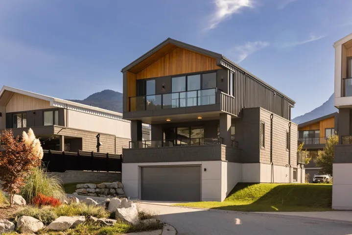 Contemporary home with a mountain view, a balcony, an attached garage, and driveway