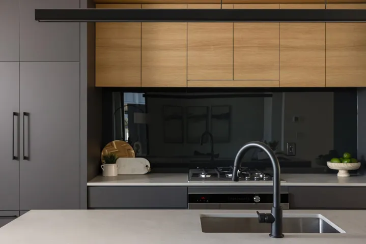 Kitchen with modern cabinets, light stone counters, and light brown cabinets