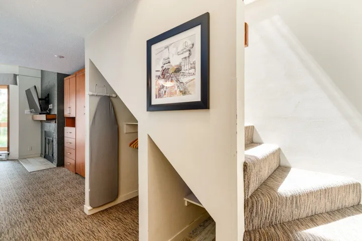 Stairway with carpet and a fireplace