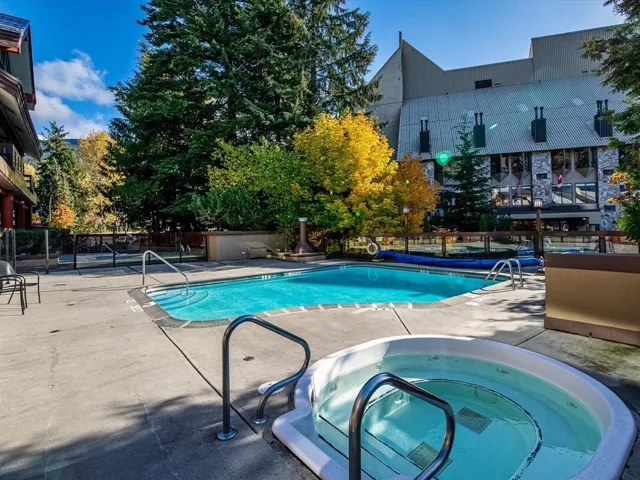 Community pool featuring a hot tub and a patio
