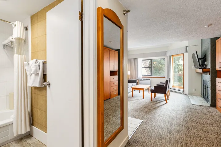 Corridor featuring light colored carpet, a baseboard radiator, and a textured ceiling