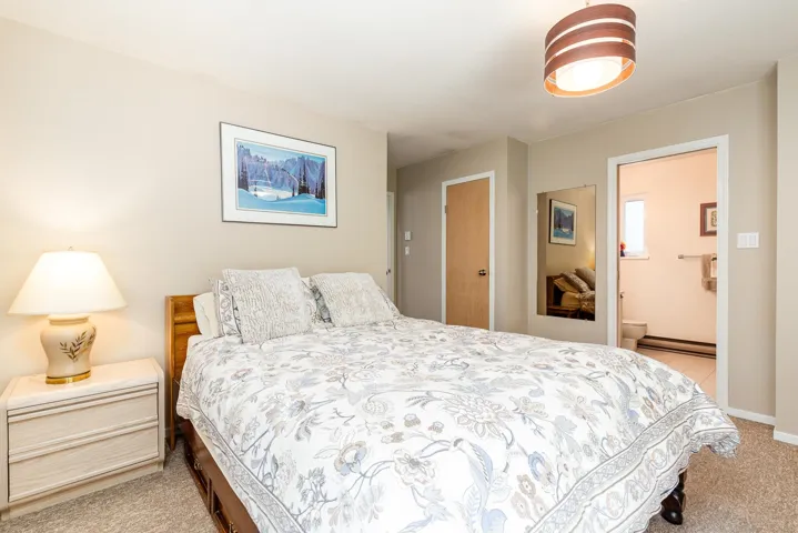 Warm-toned bedroom featuring wall-to-wall carpeting and neutral wall paint