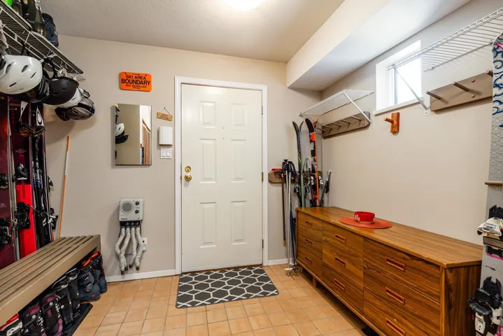 Entryway featuring tile flooring, a white paneled door, and neutral wall tones