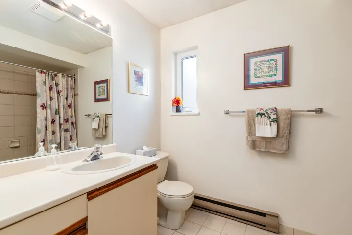 Bathroom featuring a vanity with integrated sink, a rectangular mirror, and a built-in shower/tub combination with tile surround