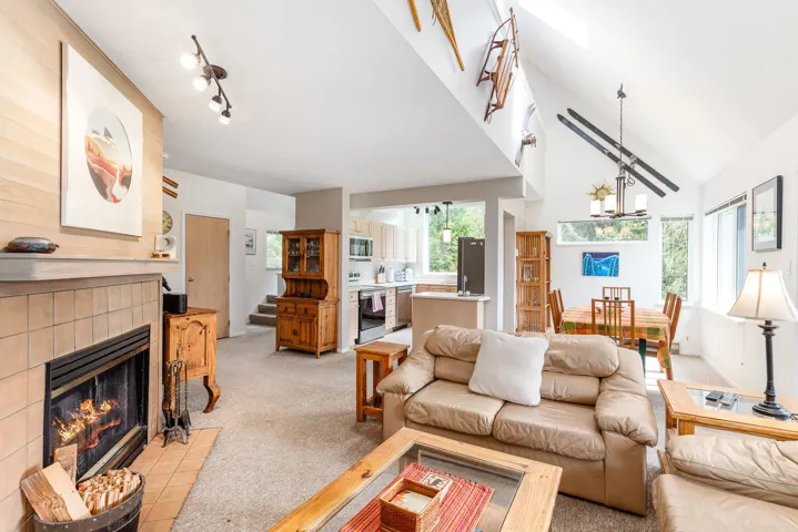 Vaulted ceilings with skylight enhance this living area featuring a tile-surround fireplace with hearth