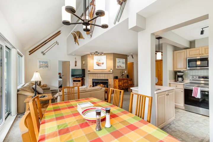 Open-concept living area with vaulted ceilings and a modern chandelier