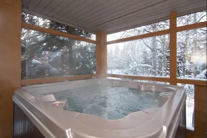 Sunroom / solarium featuring a jacuzzi and healthy amount of natural light
