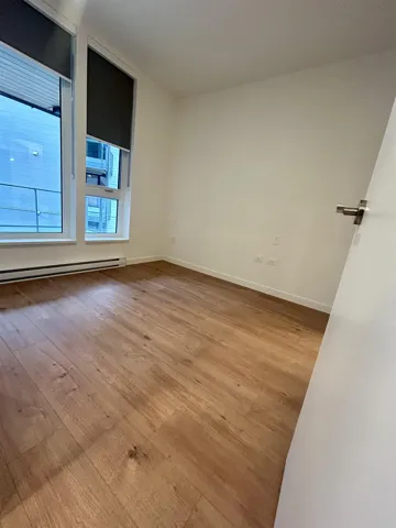 Unfurnished room with a baseboard heating unit and light wood-style flooring