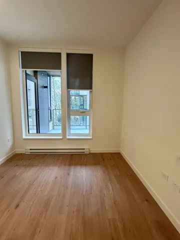 Empty room featuring a baseboard radiator and wood finished floors