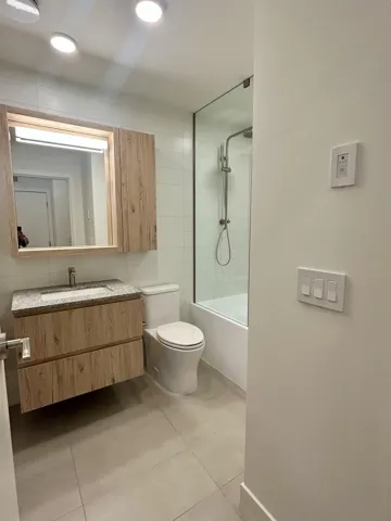 Bathroom featuring vanity, washtub / shower combination, and light tile patterned flooring