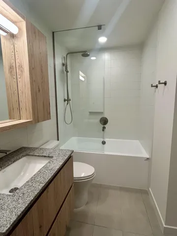 Full bath featuring vanity, shower / tub combination, and light tile patterned floors