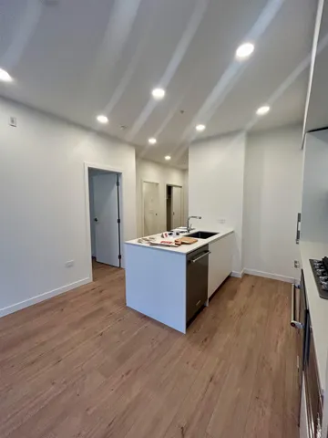 Kitchen featuring a peninsula, light countertops, modern cabinets, and light wood-style floors