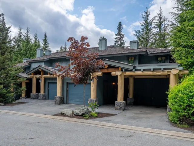 Craftsman-style house featuring asphalt driveway, a chimney, and a garage