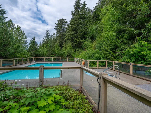 View of swimming pool featuring a forest view